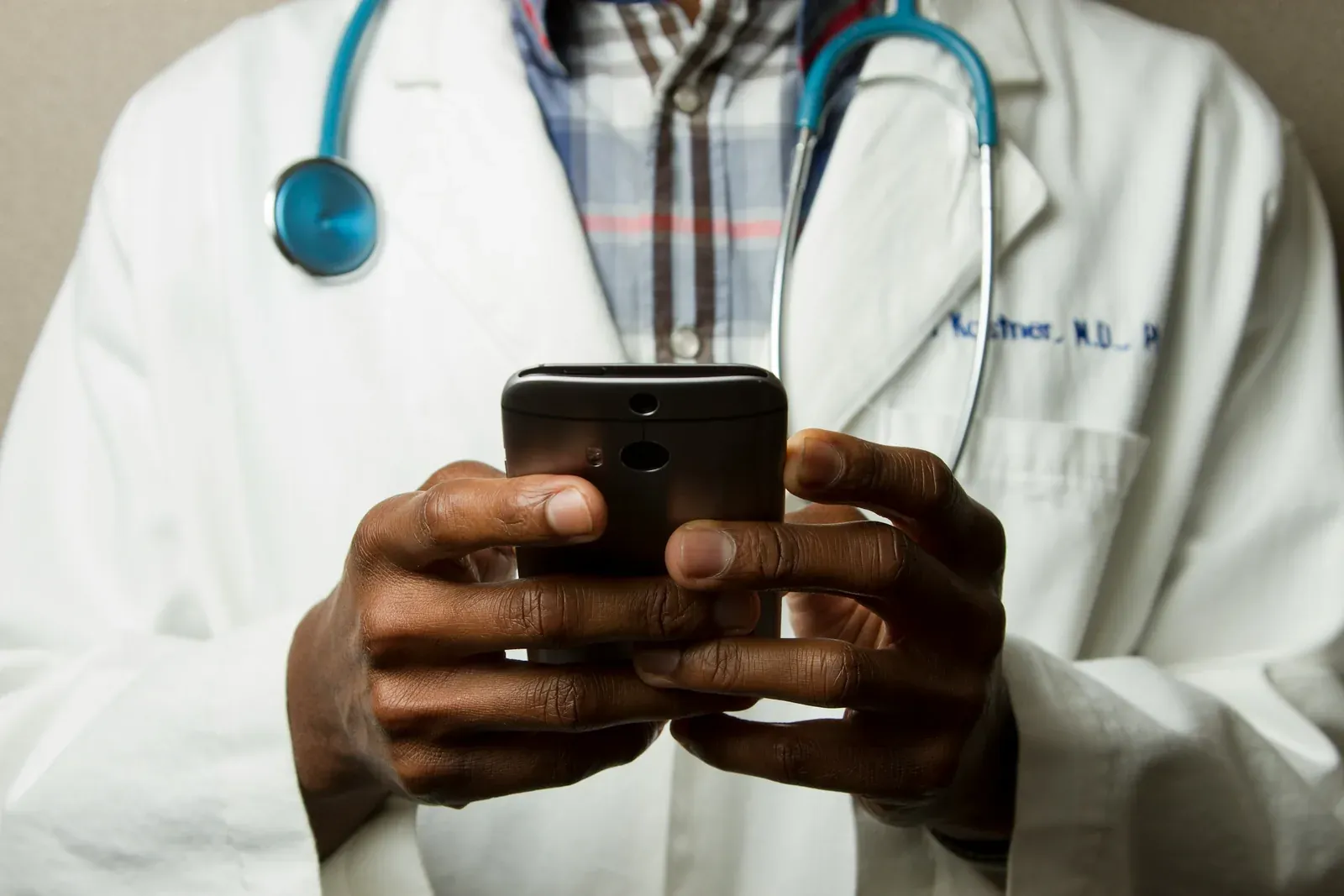 Doctor in a white coat using a phone